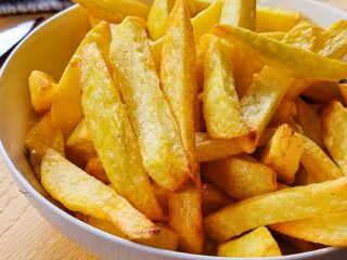 Crispy air fryer homemade french fries in a white bowl.