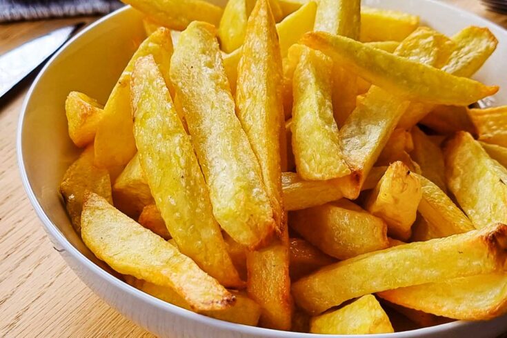 Crispy air fryer homemade french fries in a white bowl.
