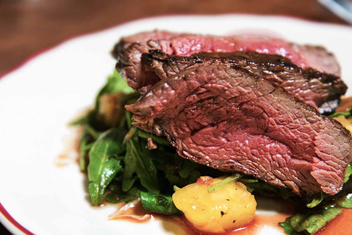 Air fryer roast beef with potatoes and spinach on a white plate