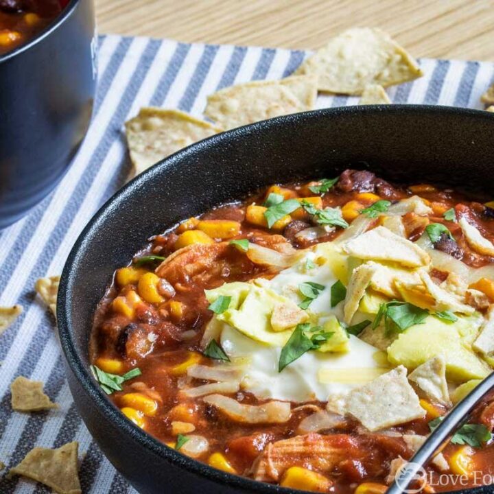 Slow cooker spicy chicken tortilla soup in a black bowl
