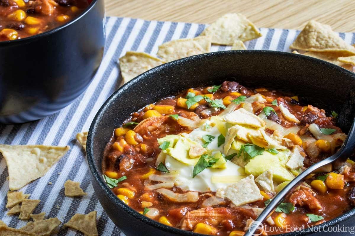 Slow cooker spicy chicken tortilla soup in a black bowl