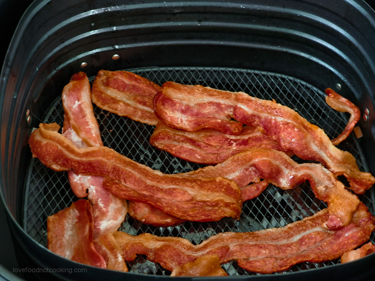 Crispy air fried bacon in the air fryer basket.