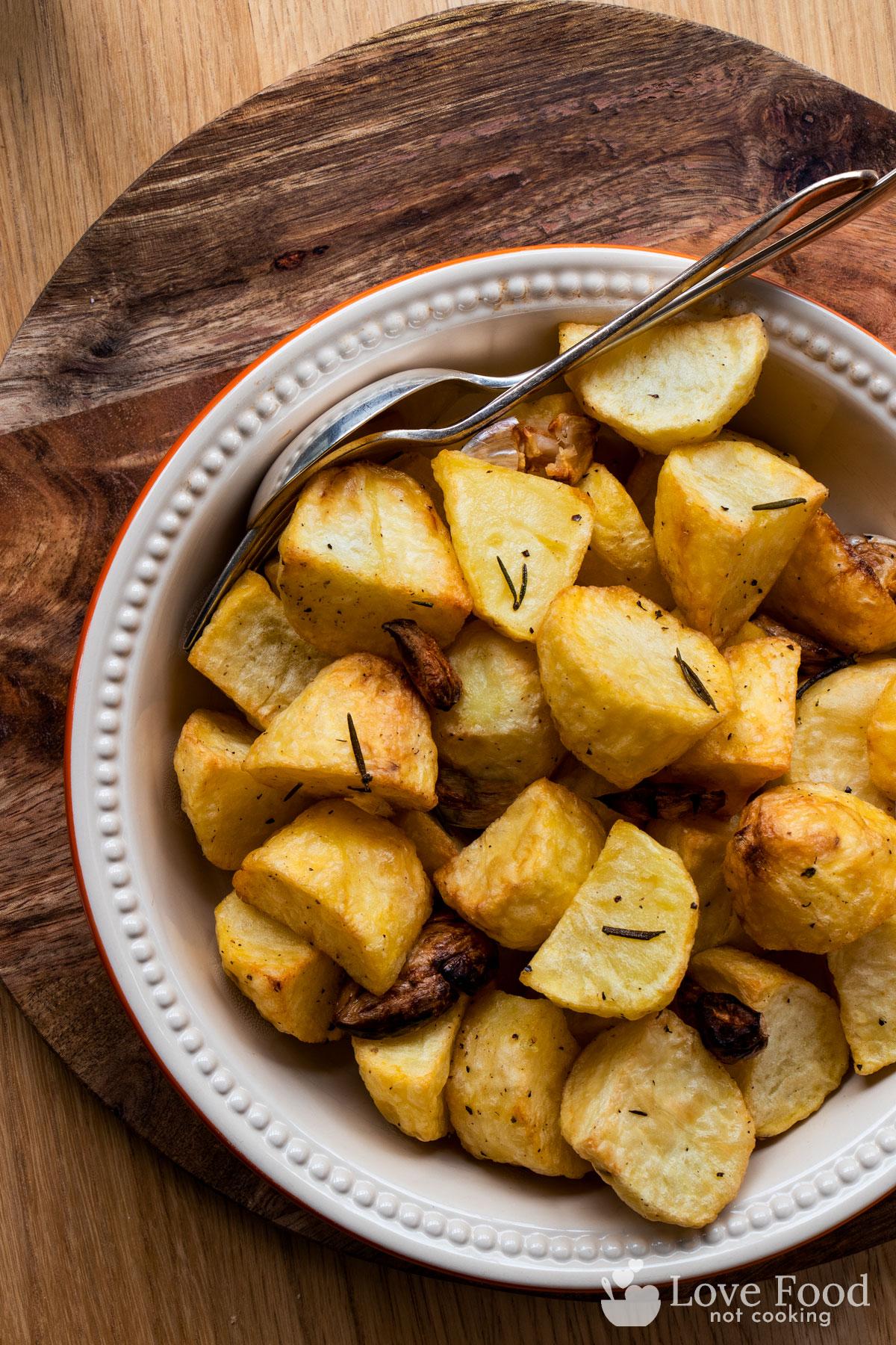 Crispy golden roast potatoes in a dish.