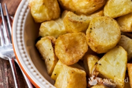 Crispy golden roasted potatoes in a dish.