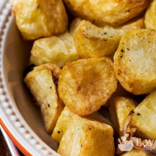 Crispy golden roasted potatoes in a dish.