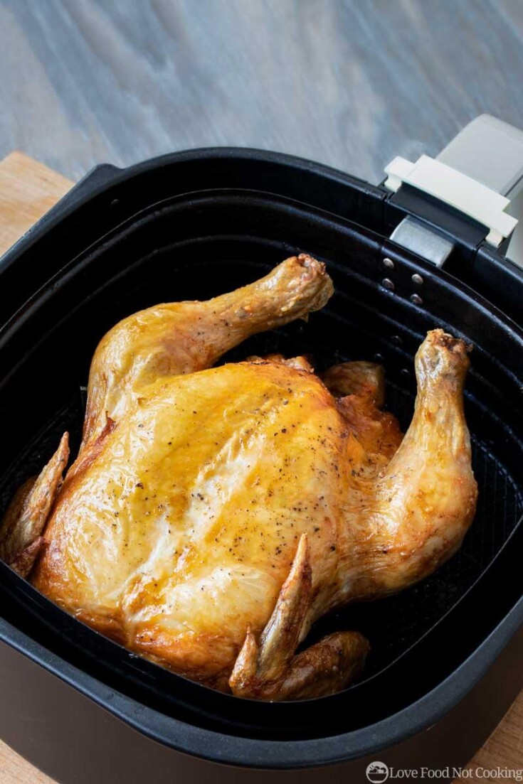 Cooked whole chicken in air fryer basket