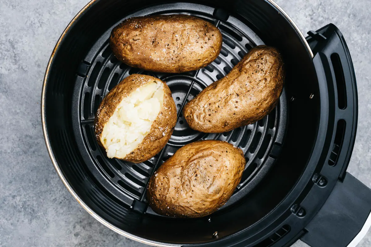 Baked potatoes in air fryer basket. 