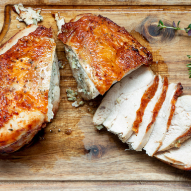 Sliced air fryer turkey breast on a wooden board.