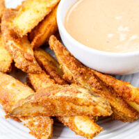 Air fryer potato wedges on a wite plate.