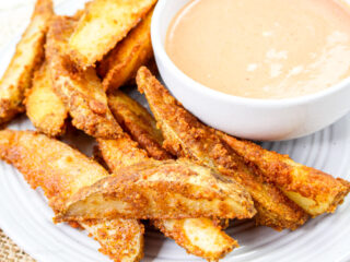 Air fryer potato wedges on a wite plate.