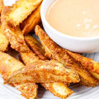 Air fryer potato wedges on a wite plate.
