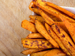 Sweet potato fries on a wooden board.