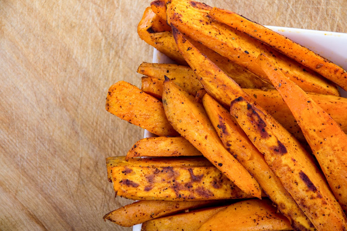 Sweet potato fries on a wooden board. 