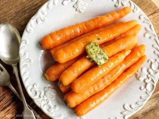 Microwave steamed carrots on a white plate with butter.