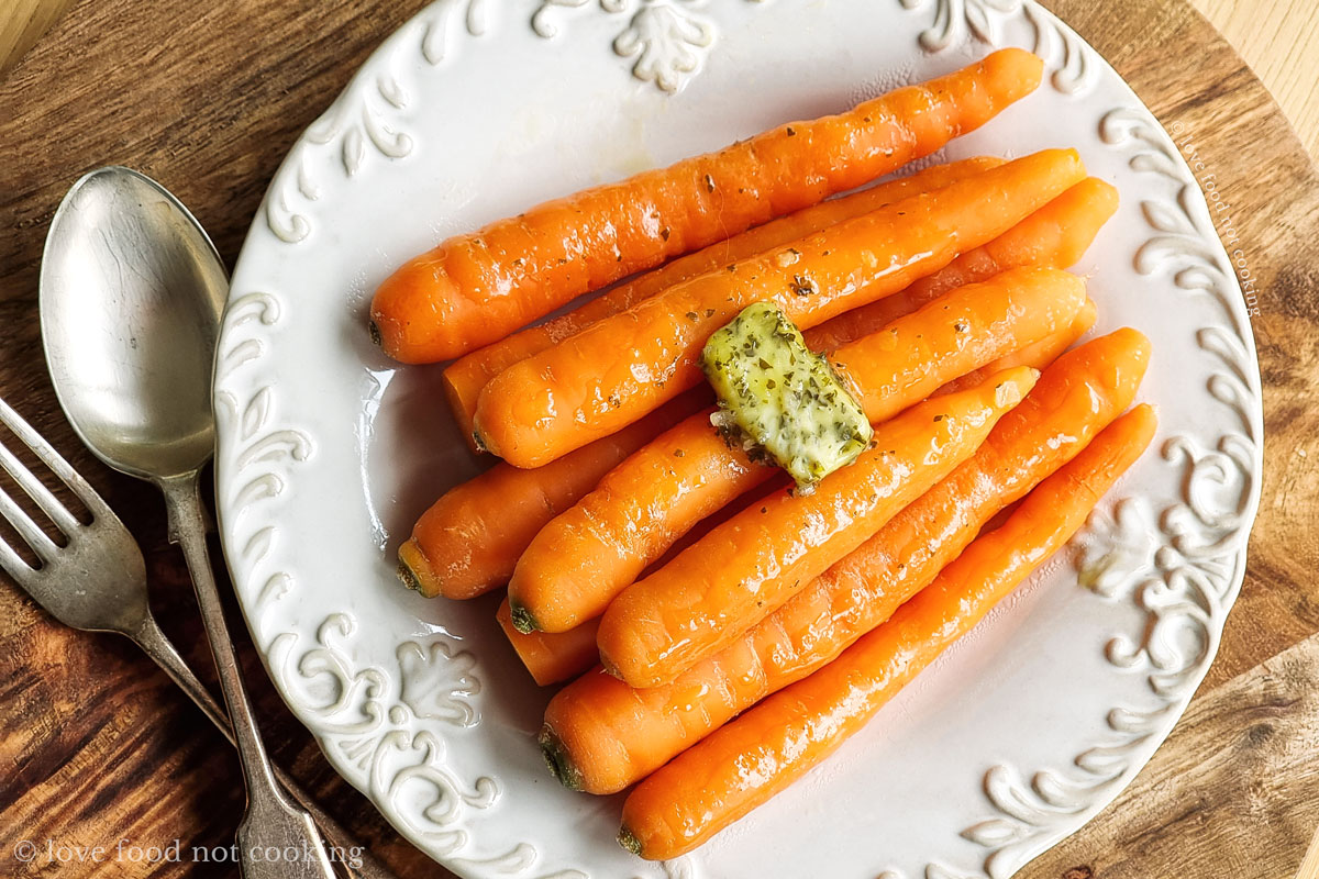 Microwave steamed carrots on a white plate with butter. 