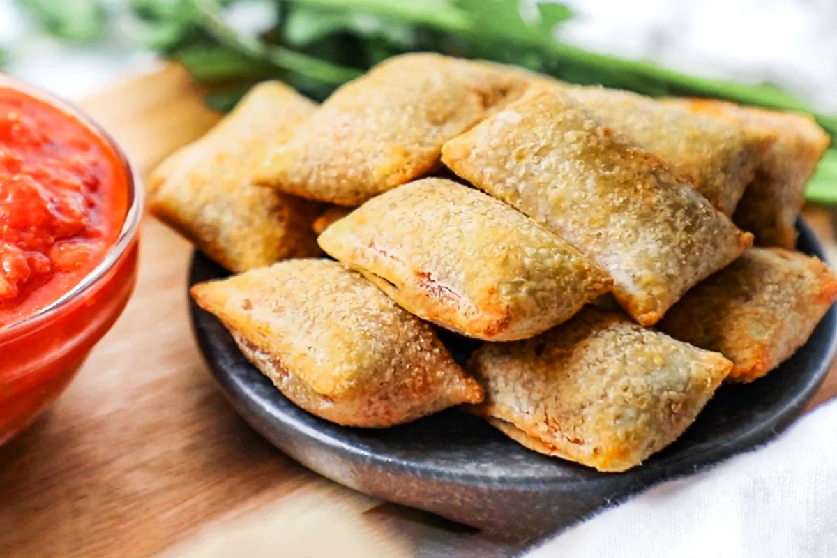 Air fryer pizza rolls on a black plate. 