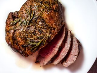 Air fryer roast lamb on a white plate.