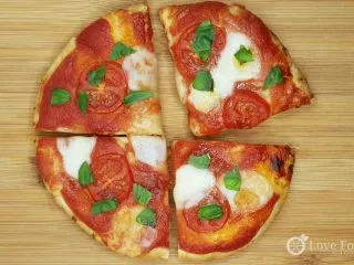 Air fryer pizza on a wooden board.
