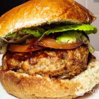 Air fried pork burger with salad and bbq sauce.