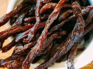 Air fried beef jerky strips in a white bowl.