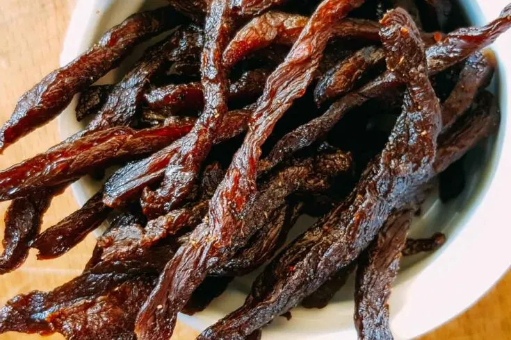Air fried beef jerky strips in a white bowl.
