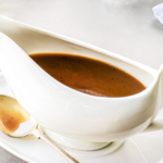 Gravy made from stock in a white gravy boat.