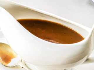 Gravy made from stock in a white gravy boat.