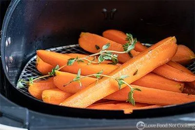 Raw carrots in air fryer basket