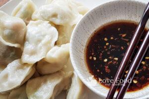 Steamed Dumplings om a plate with a bowl of dipping sauce