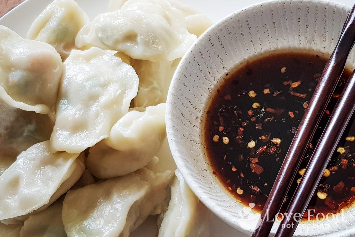 Steamed Dumplings on a plate with a bowl of dipping sauce
