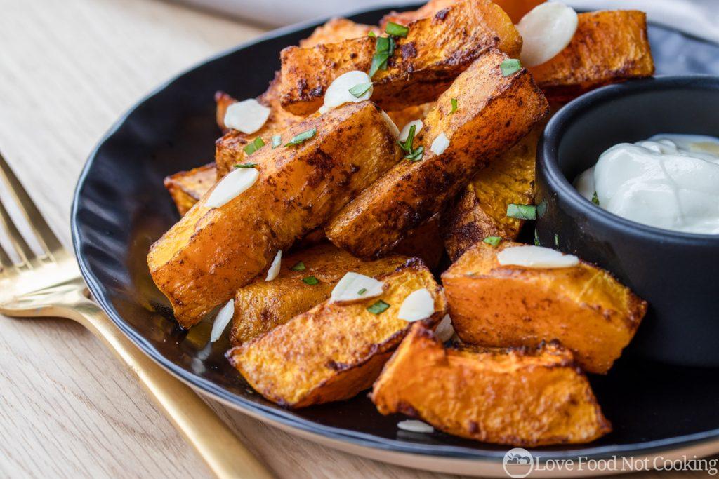 Air Fried Butternut Squash on a black plate with a white dip