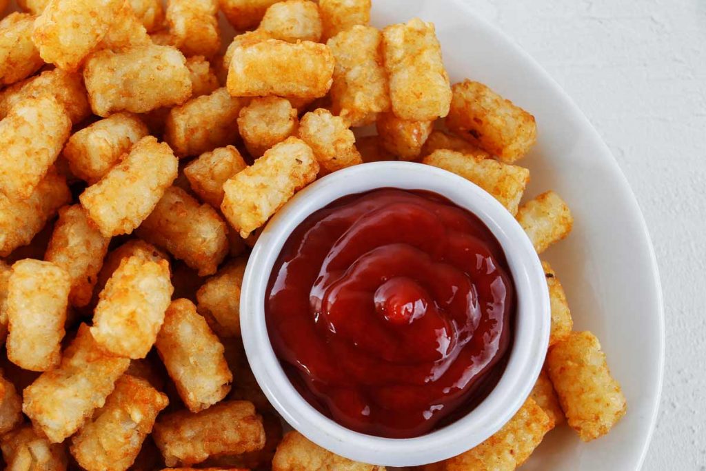 Air Fryer frozen tater tots on a white plate