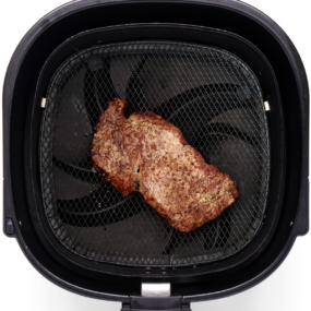 Leftover steak being reheated in an air fryer.