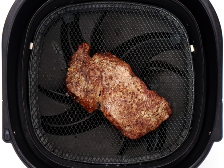 Leftover steak being reheated in an air fryer.