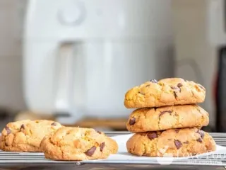 Cookies baked in an air fryer, with an air fryer in the background.