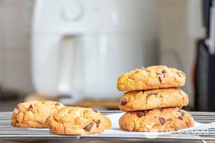 Cookies baked in an air fryer, with an air fryer in the background.