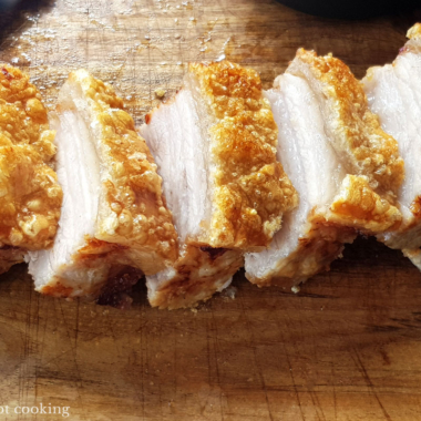 Air fryer pork belly sliced on a wooden board.