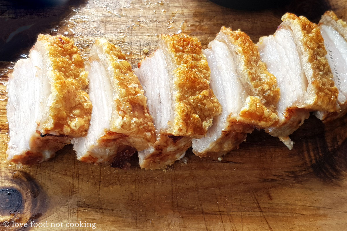 Air fryer pork belly sliced on a wooden board. 