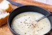 Instant Pot Potato and Leek Soup in a black bowl with crusty bread