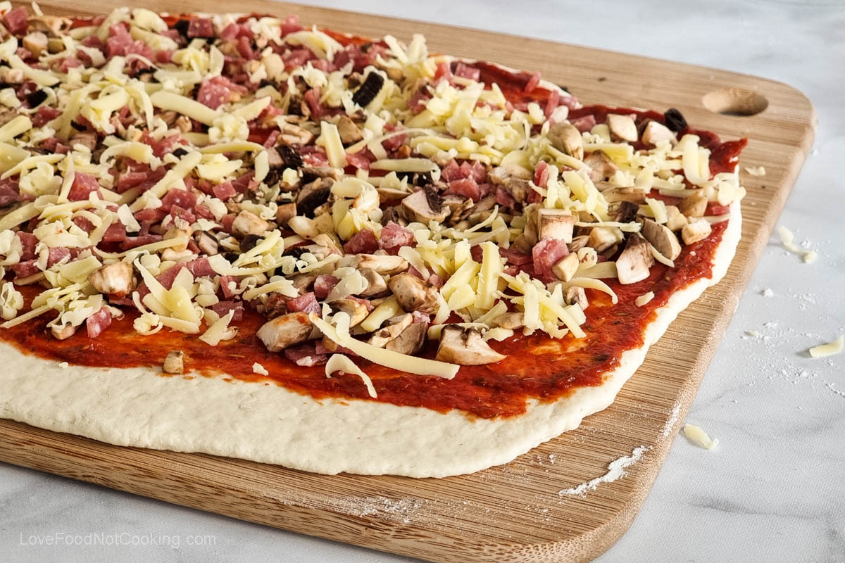 Pizza toppings on the rolled out dough. 