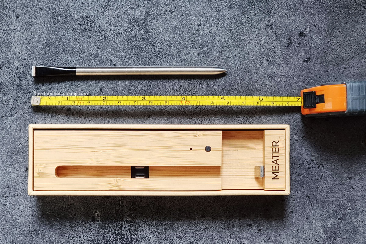 Meater thermometer probe and storage block with tape measure.
