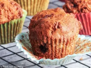 Air fryer banana muffins in colorful muffin cases on a black cooling rack.