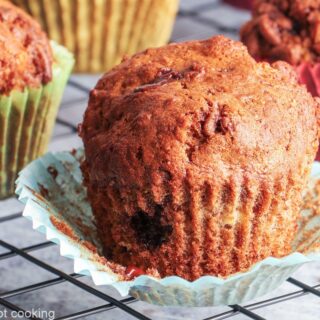 Air fryer banana muffins in colorful muffin cases on a black cooling rack.
