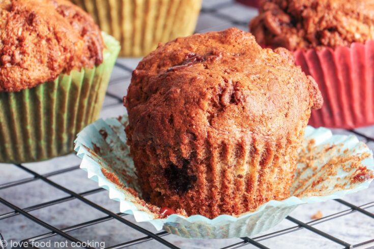Air fryer banana muffins in colorful muffin cases on a black cooling rack.