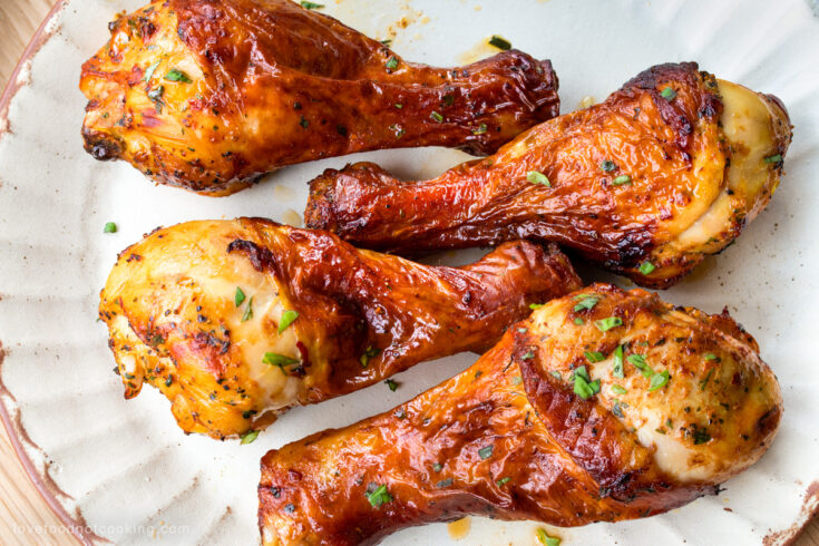 Air fryer chicken drumsticks on a cream-colored plate.