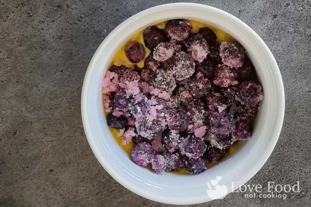 Instant Pot blueberry cobbler assembled ingredients in a white baking dish. 