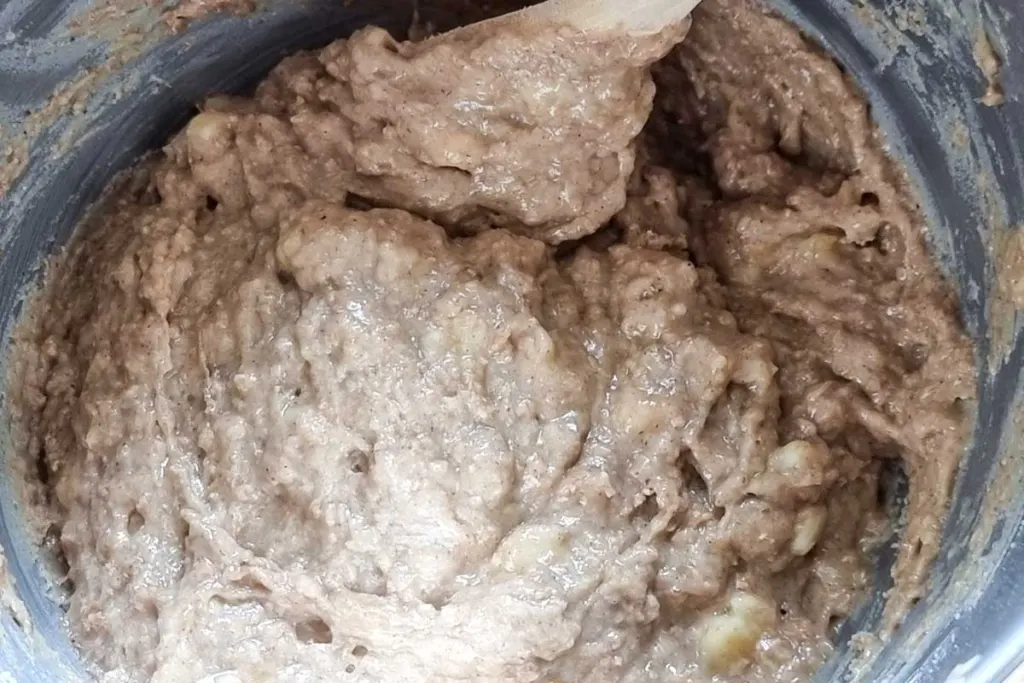 Banana muffin batter in a stainless steel bowl.