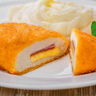 Chicken cordon bleu cut open on a white plate.