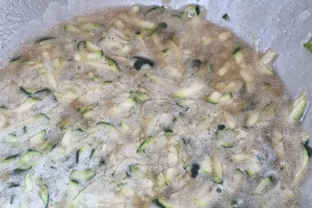 Wet ingredients for air fryer zucchini recipe mixed in a stainless steel bowl. 