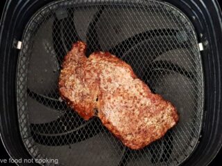 Leftover steak being reheated in an air fryer.